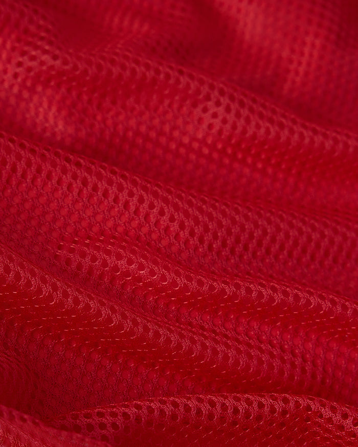 Red swim short fabric with quilted texture and visible stitching details.