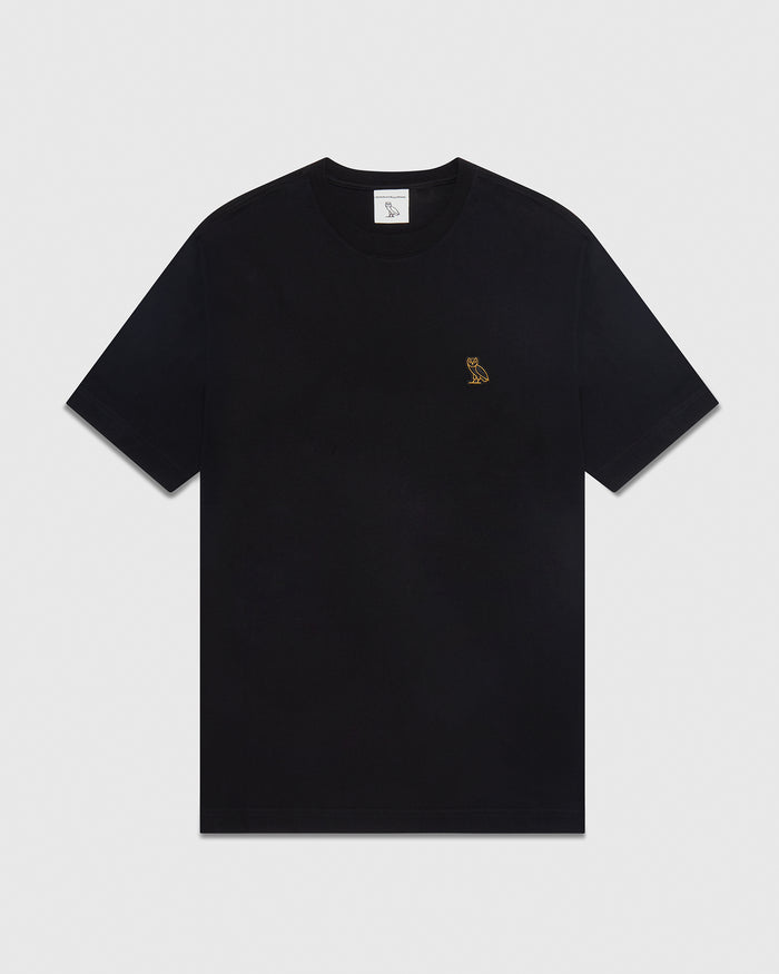 Black crew neck t-shirt with small gold embroidered logo on chest.
