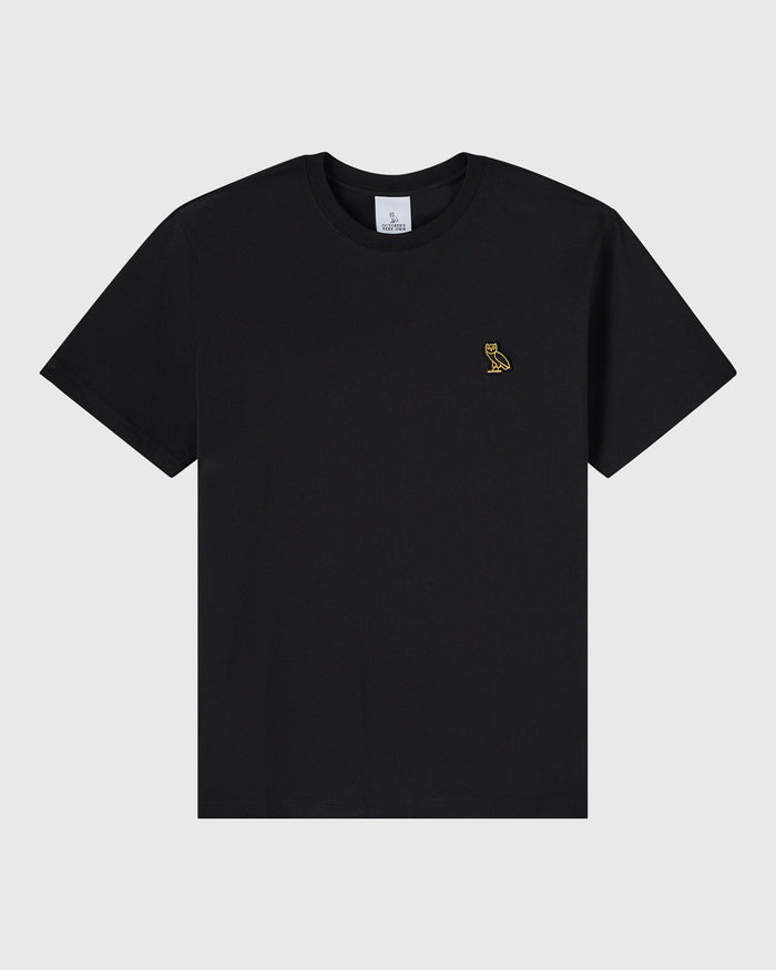 Black crewneck t-shirt with small gold owl emblem on chest.