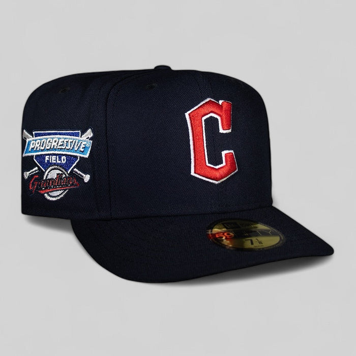 A navy blue baseball cap with the Cleveland Guardians logo on the front and Progressive Field logo on the side.