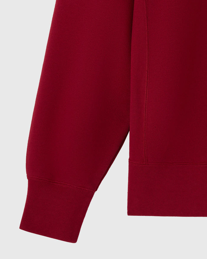 Deep red crewneck sweatshirt with ribbed cuffs and hem detail.