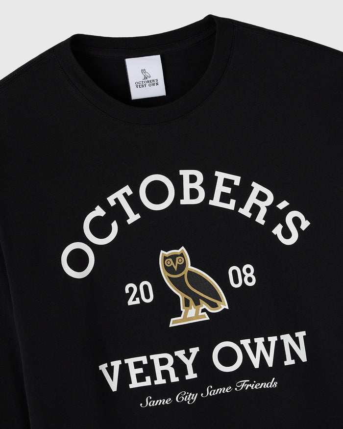 Black long-sleeve tee with white "October's Very Own" text, gold owl graphic, and "Same City Same Friends" slogan.