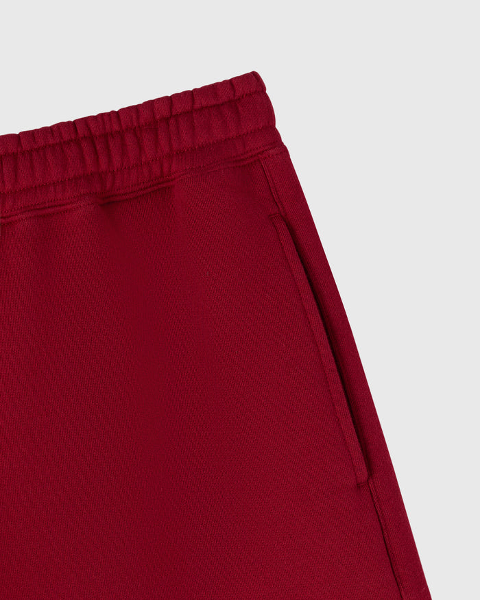 Deep red shorts with ribbed elastic waistband and side pocket detail.