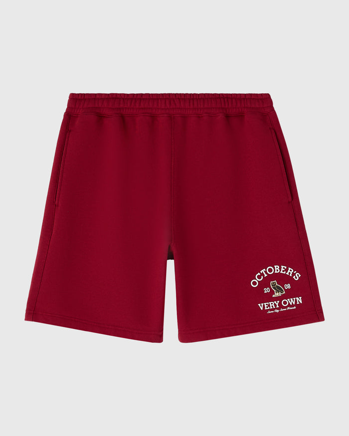 Deep red shorts with elastic waistband and side pockets, featuring "October's Very Own" text graphic on right leg.