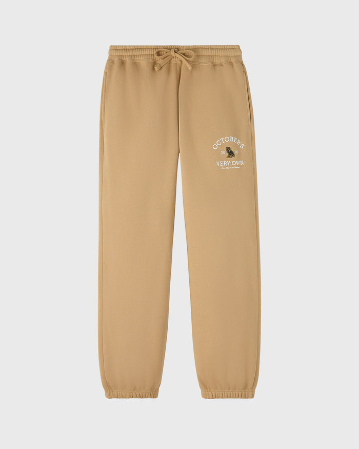 Tan sweatpants with drawstring waist and embroidered "October's Very Own" text on thigh.