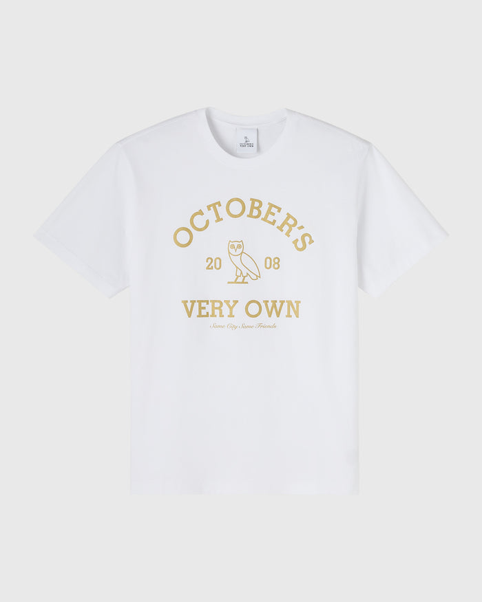 White short-sleeve t-shirt with gold collegiate graphic featuring "October's Very Own" text and owl icon.