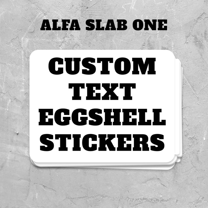 Stack of custom text eggsell stickers with 'Alfa Slab One' text on a gray textured background.