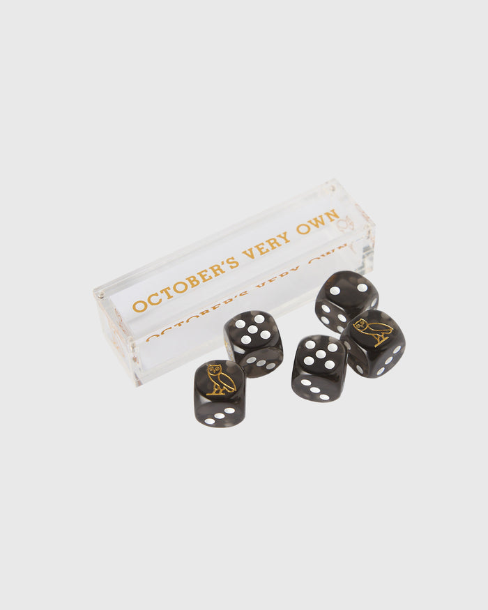 Set of five black dice with white dots and gold owl symbols, displayed with clear acrylic storage box.