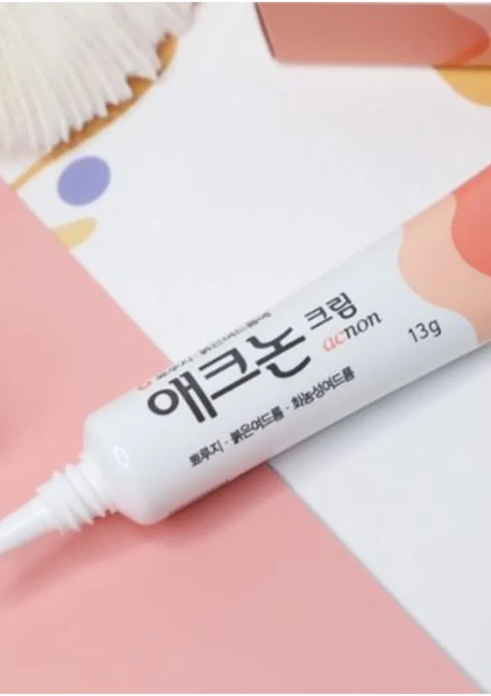 Cosmetic tube labeled 'acnon' on a pink background