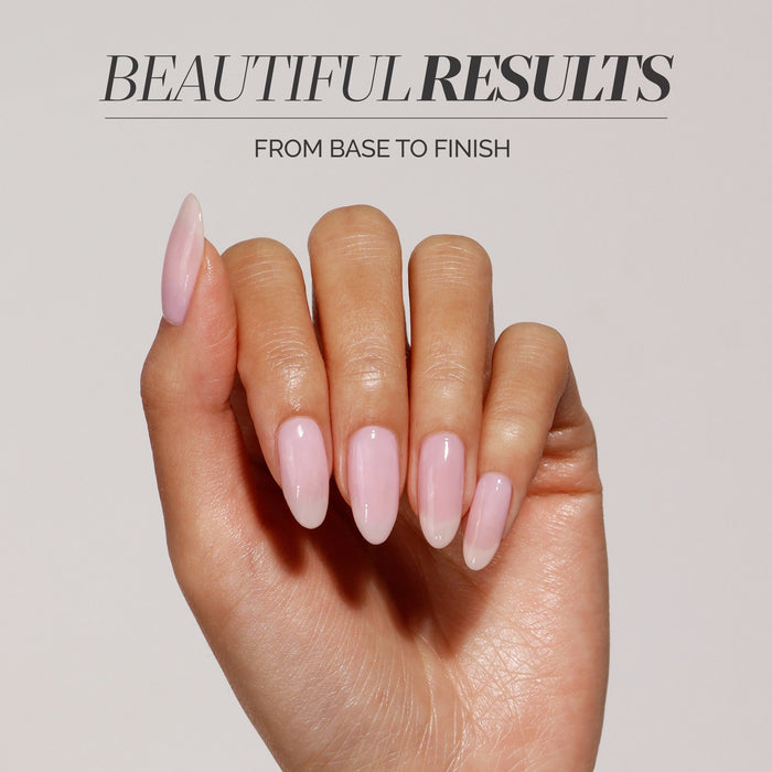 A hand with long, almond-shaped, glossy light pink nails is shown against a plain background, showcasing "Beautiful Results From Base to Finish"—just like LONDONTOWN’s Full Service Base + Top Coat delivers flawless nails every time.