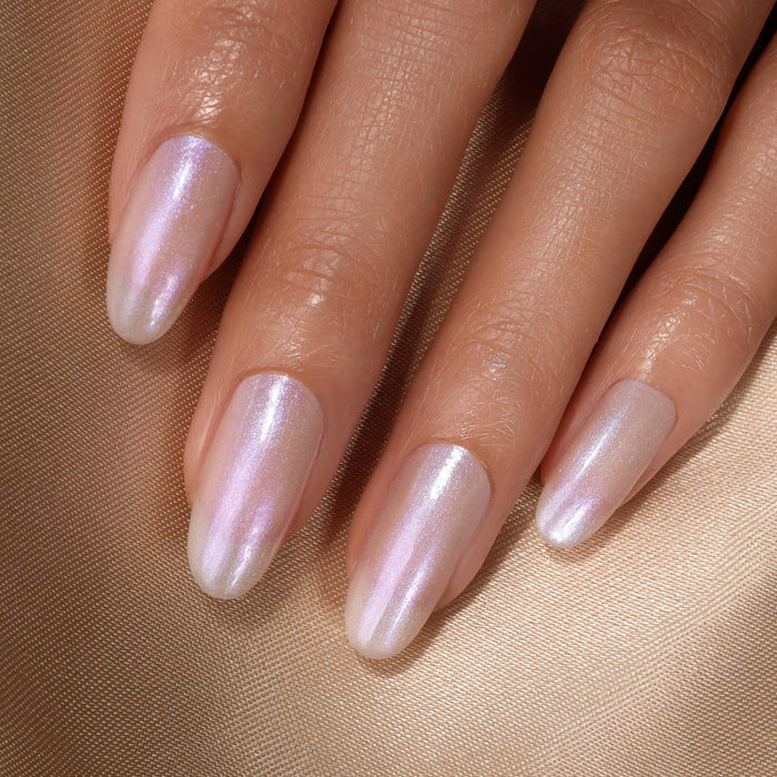 A close-up of long, almond-shaped nails painted in shiny, iridescent light pink polish with a sparkling finish—created using LONDONTOWN's Full Service Base + Top Coat.