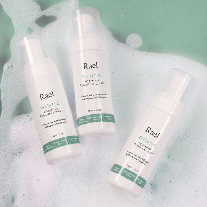 3 pump bottles of Rael Gentle Foaming Feminine Wash with a foam background.