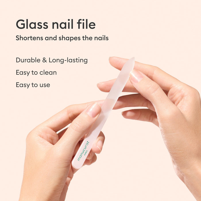 A person uses the Manucurist-us Glass Nail File to shape their nails. Text on the image highlights this reusable file’s durability, ease of cleaning, simple use, and ability to quickly shorten and shape nails.