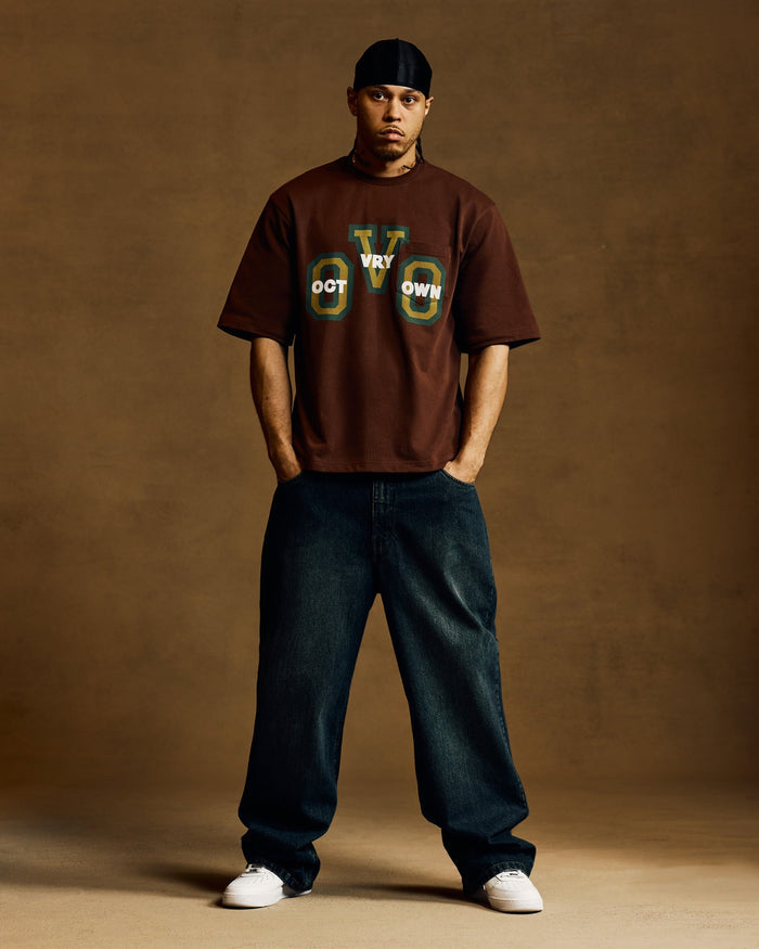Hickory brown short-sleeve t-shirt with chest graphic print, worn with dark jeans.