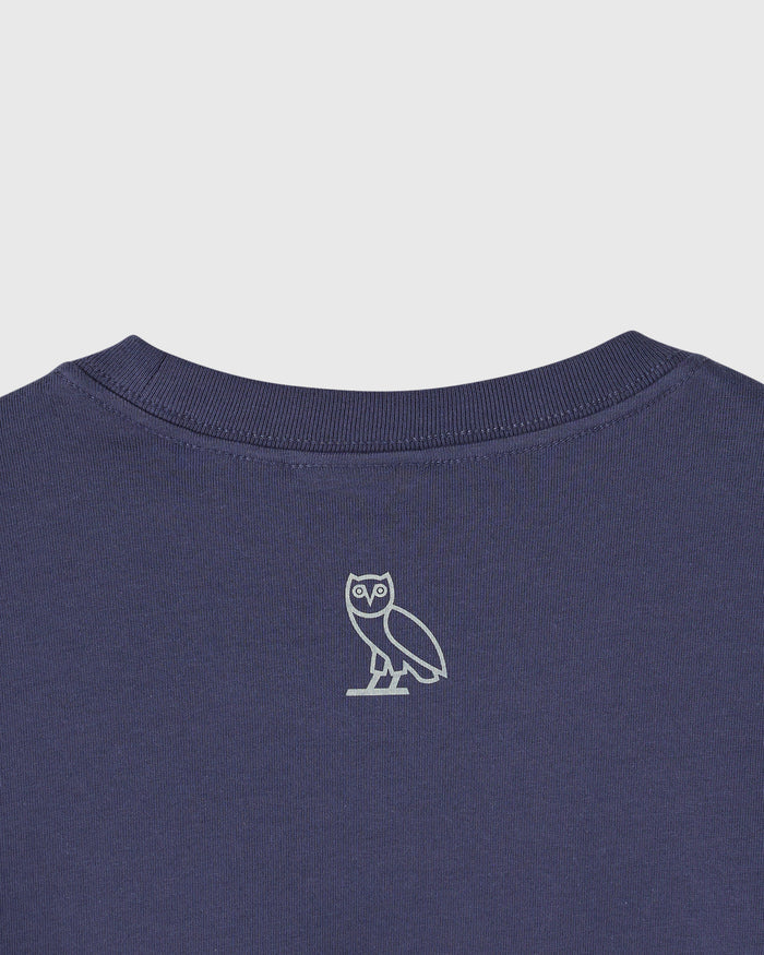 Navy blue t-shirt with small owl emblem centered on chest and ribbed crew neckline.