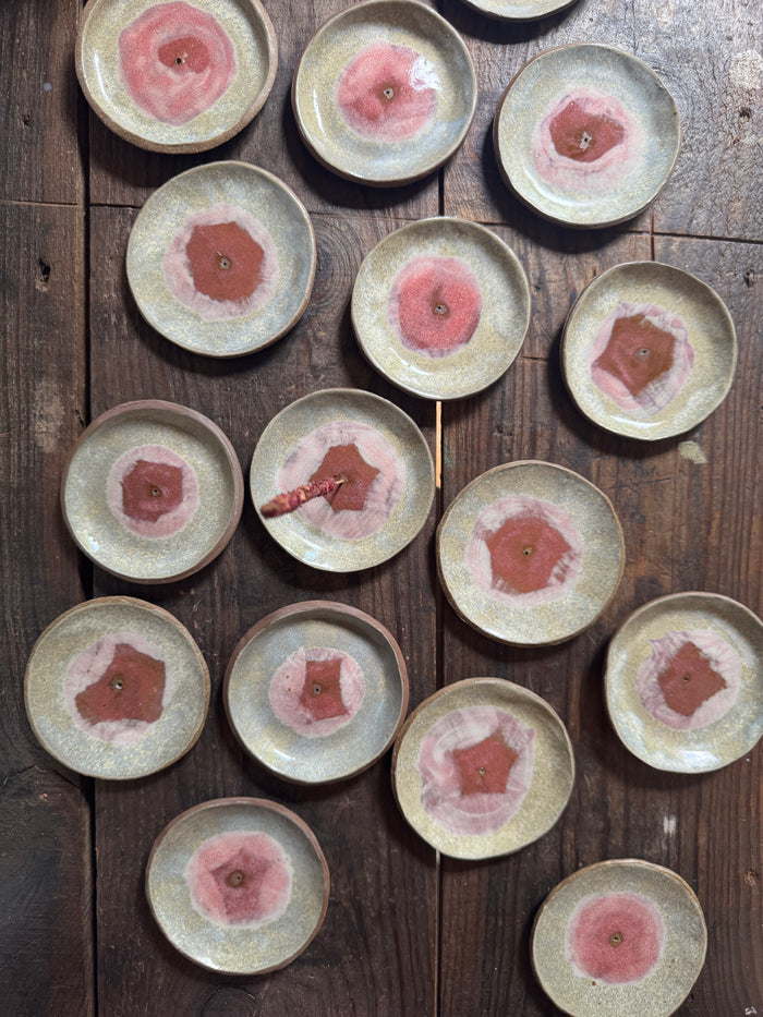 Set of ceramic plates with pink floral designs on a wooden surface