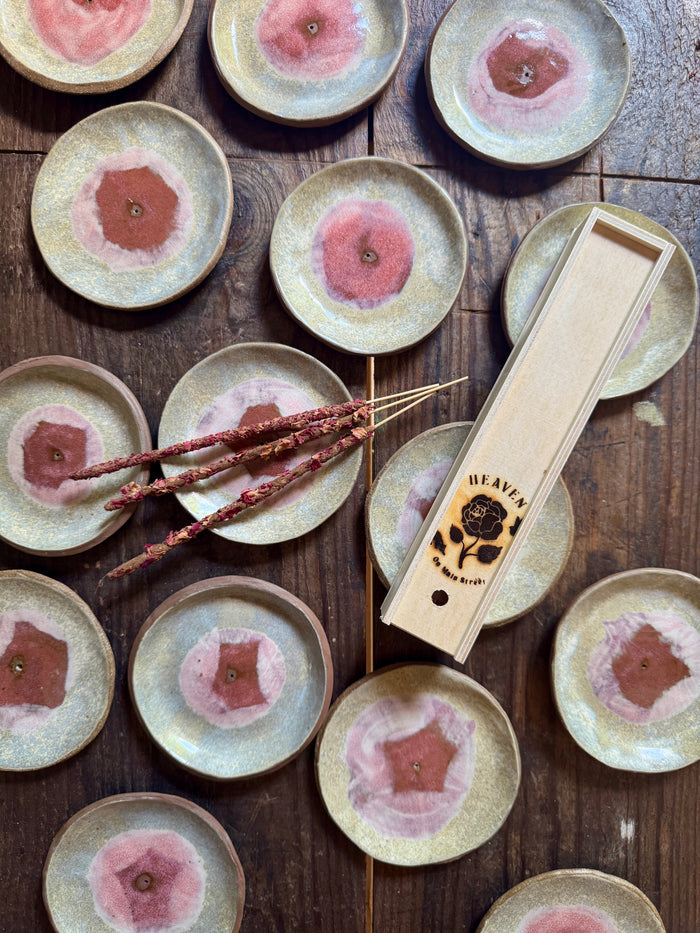 Set of ceramic plates with floral designs on a wooden surface, accompanied by a wooden tool with 'HEAVA' branding.
