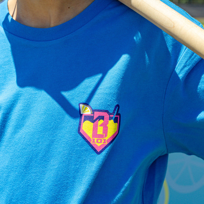 Youth model wearing blue youth graphic tee with "Lemonade" design