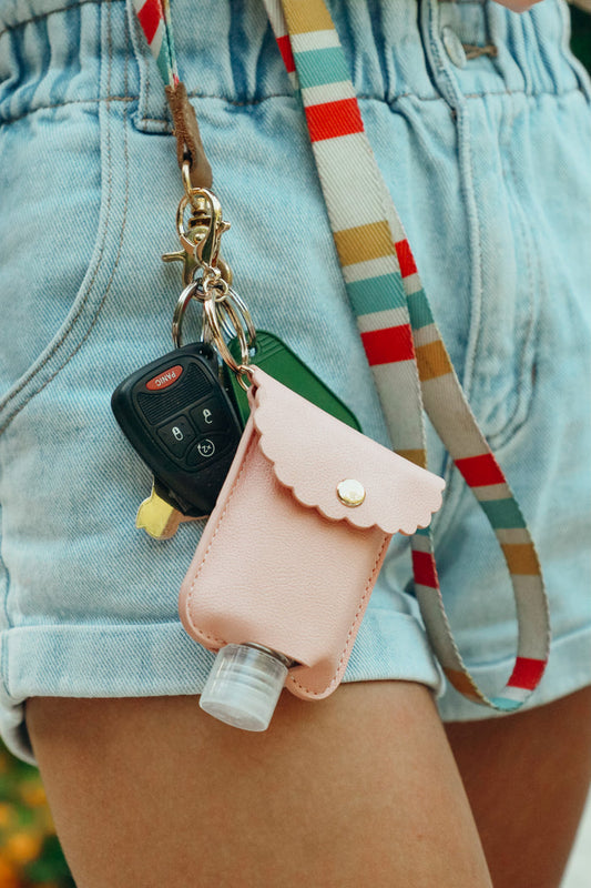 girl shows off her hand sanitizer case on a keychain
