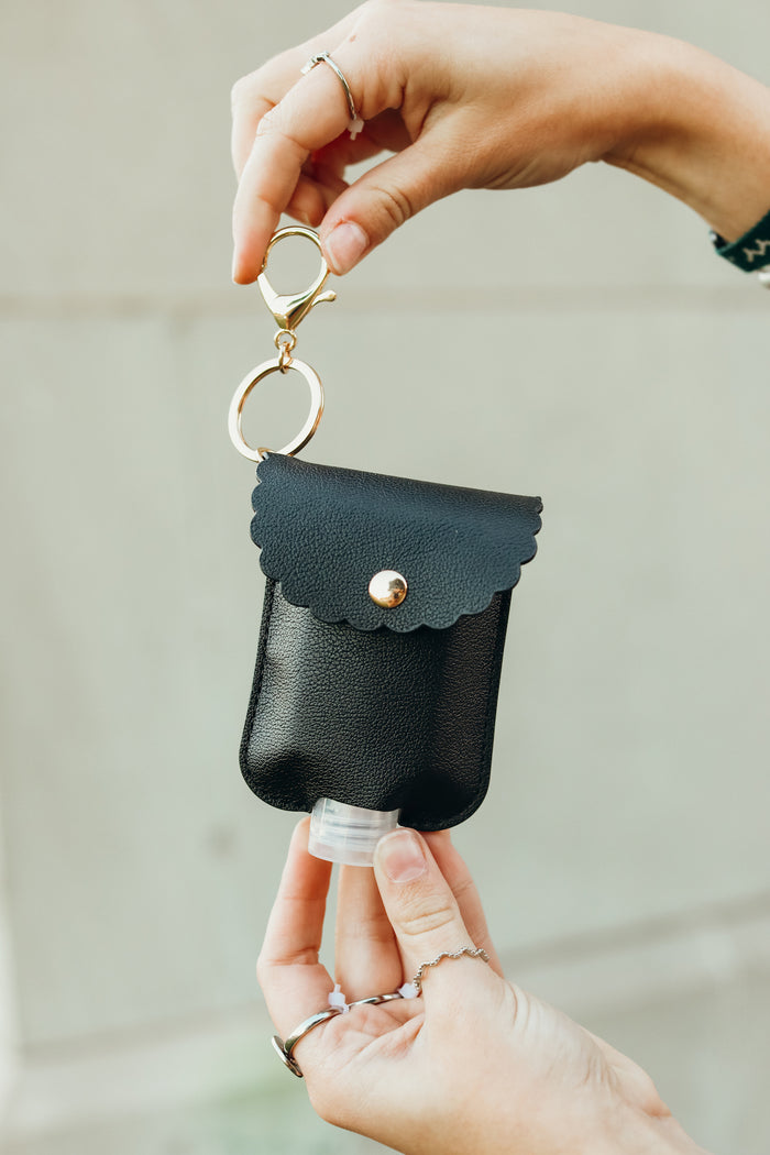 girl shows off her hand sanitizer case on a keychain