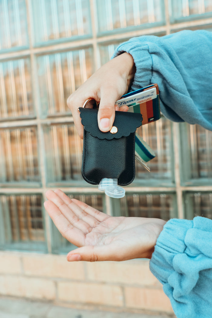girl shows off her hand sanitizer case on a keychain