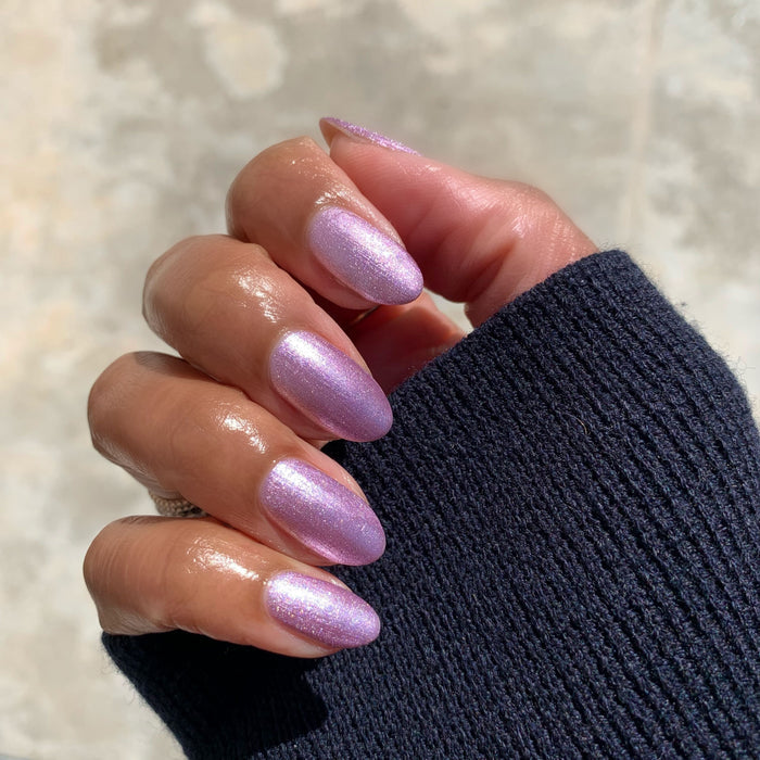 Hand with nails painted in Lilac Shimmer showing a soft metallic purple manicure perfect for at-home nail polish looks