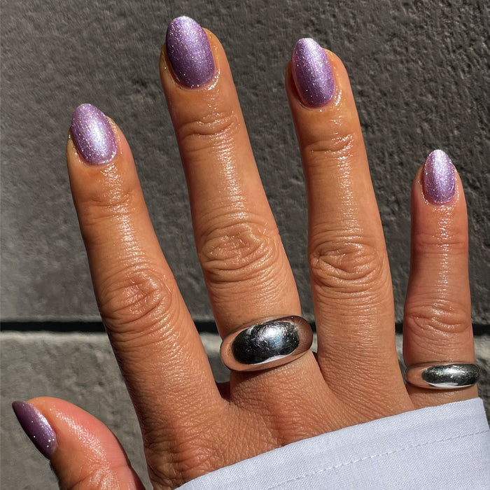 Hand with nails painted in Lilac Shimmer showing a metallic lilac polish for a bright and stylish manicure look