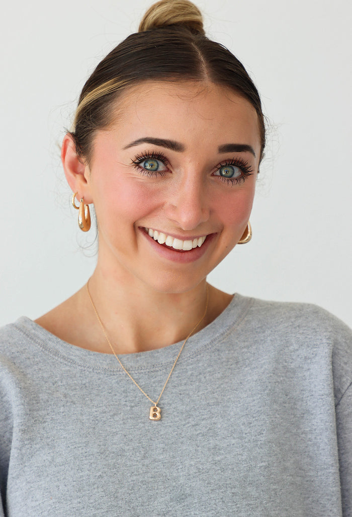 girl wearing gold letter "B" necklace