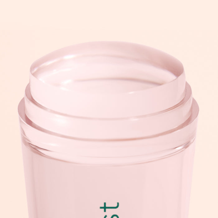A close-up of the Mani stamper by Manucurist US, a light pink, transparent stick with a rounded, glossy surface, shown against a pale background—evoking the look of flawless French tips.