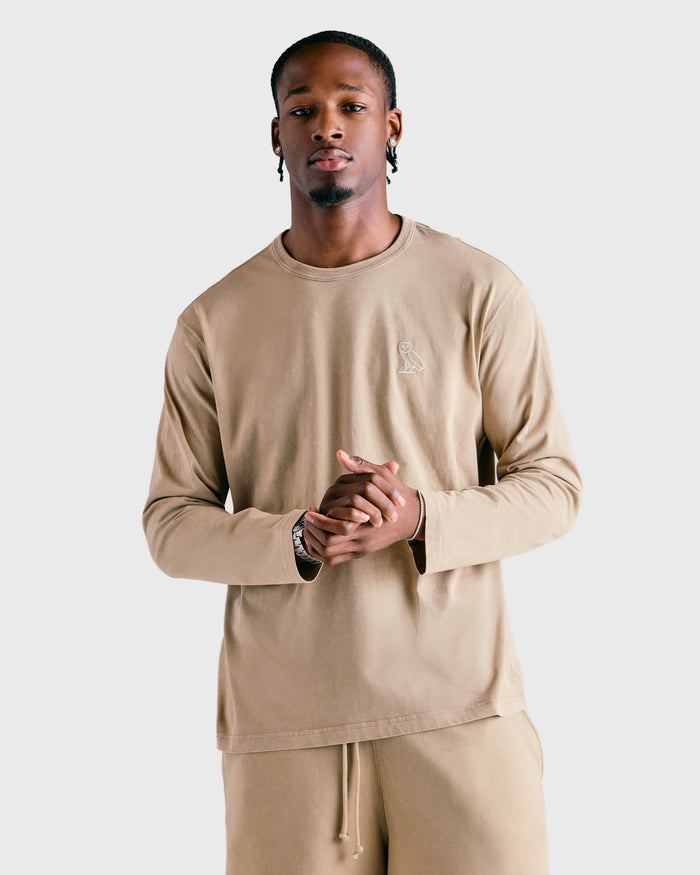 Sandstone long-sleeve tee with crew neckline and small chest logo, worn by model.