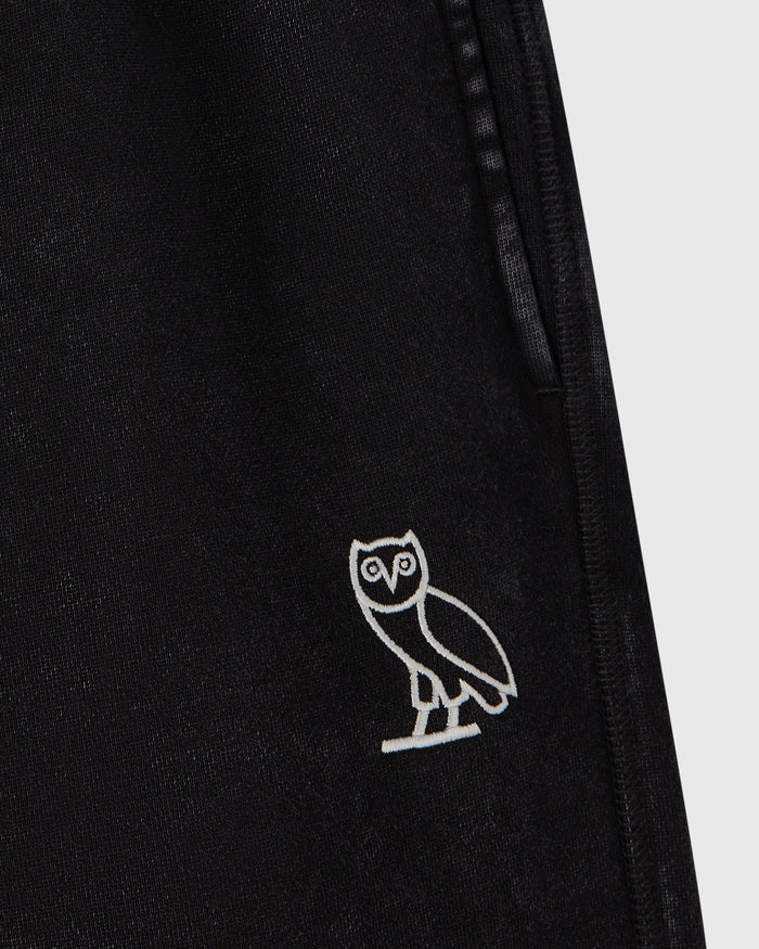Black sweatpants with white owl embroidery on leg and side seam detail.