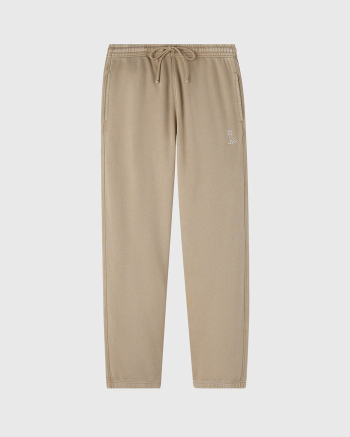 Beige sweatpants with drawstring waist, small embroidered logo on thigh, and straight leg silhouette.