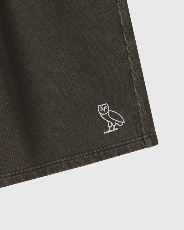 Deep olive sweatshorts with white owl logo embroidered on thigh.