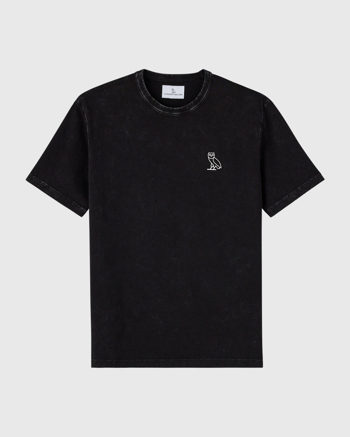 Black garment-dyed t-shirt with small white owl logo on chest and crew neckline.