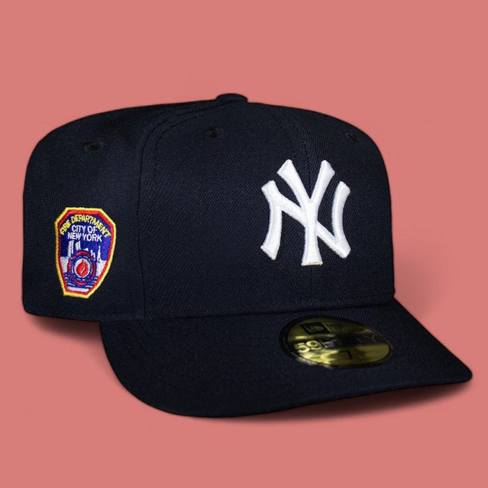 A navy blue baseball cap with the New York Yankees NY logo in white on the front, and a FDNY patch on the side.