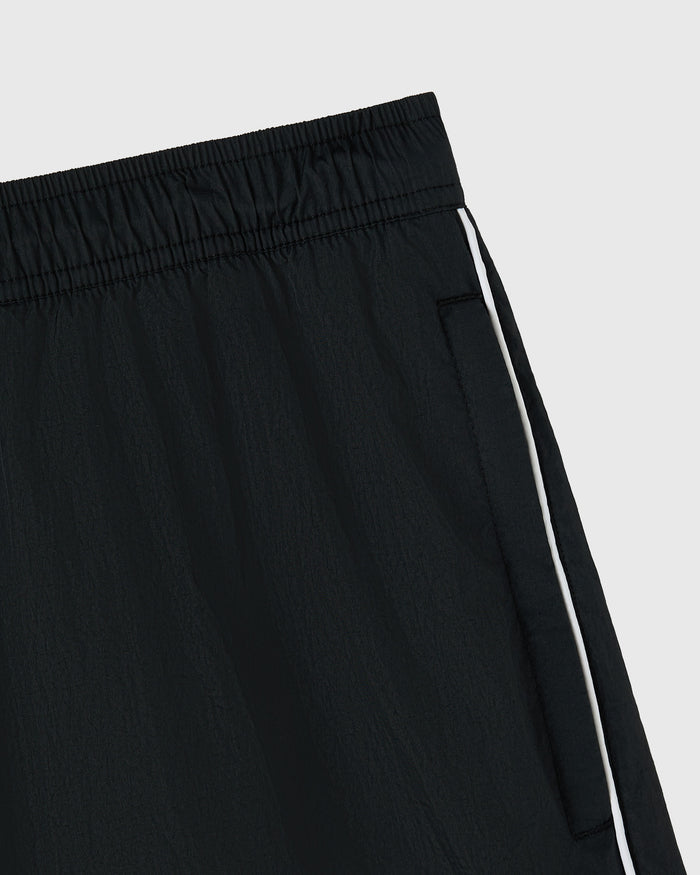 Black nylon track short with white stripe detail on side seam and elastic waistband.