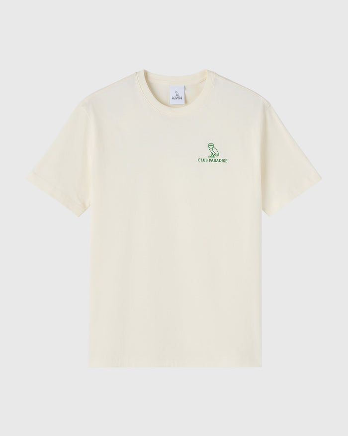 Cream-colored short-sleeve t-shirt with green owl logo and "Club Paradise" text on chest.