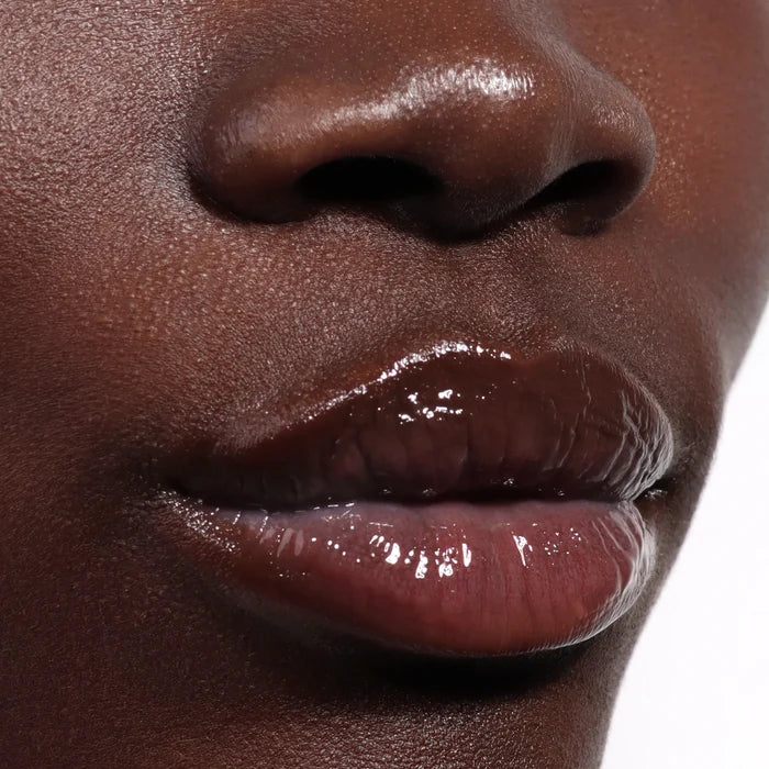 Close-up of smooth dark skin and lips with a plush shine, thanks to LONDONTOWN's Quench Glow Buttery Lip Oil in Au Naturale.
