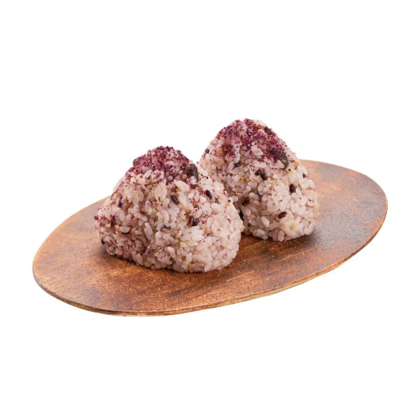 Three rice balls with red pepper flakes on a wooden plate against a white background