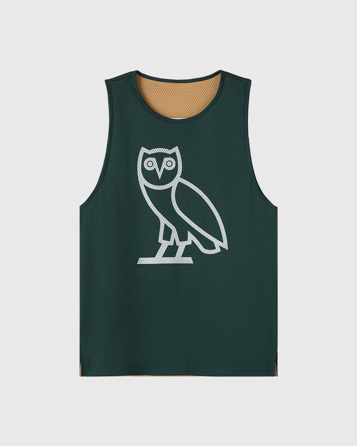 Reversible mesh basketball jersey with dark green side featuring white owl graphic and camel mesh lining visible at neckline.