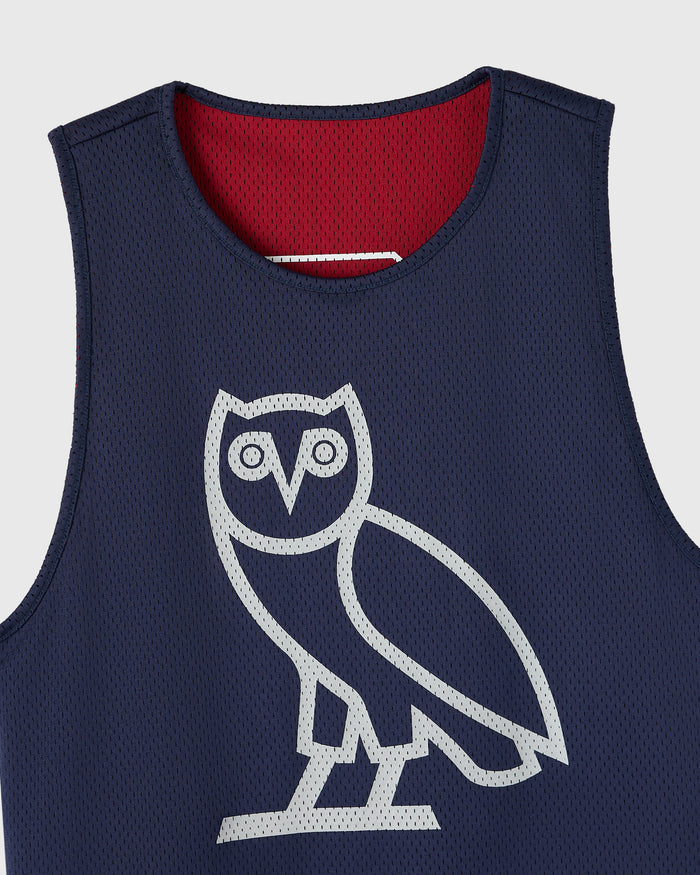 Reversible mesh basketball jersey with navy exterior, deep red interior, and white owl graphic on chest.