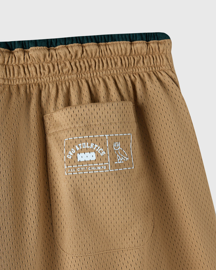 Camel mesh shorts with elastic waistband, front pocket, and dark teal interior lining visible at top.