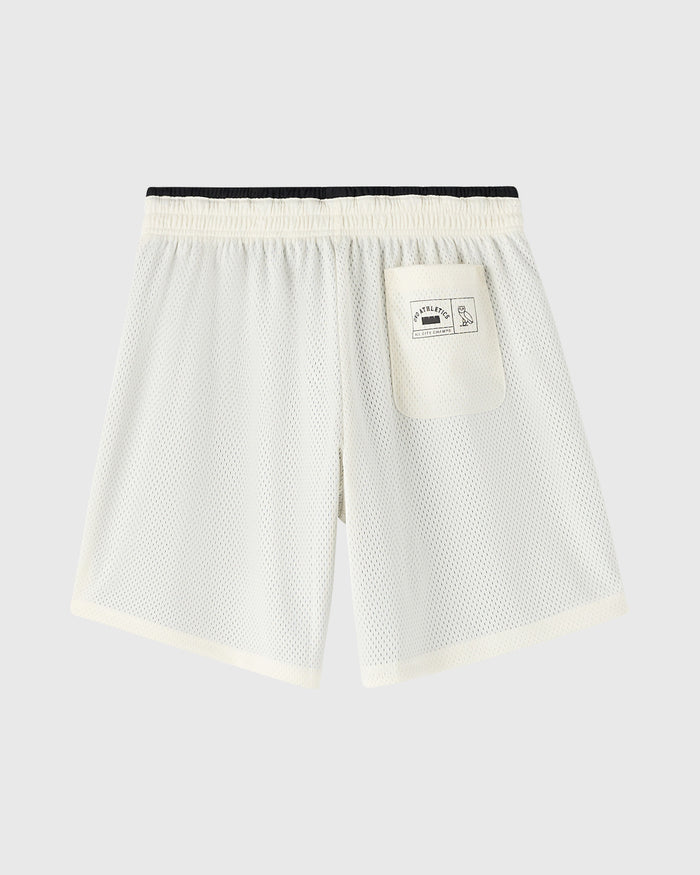 Cream mesh shorts with black elastic waistband, back pocket, and cream trim at legs.
