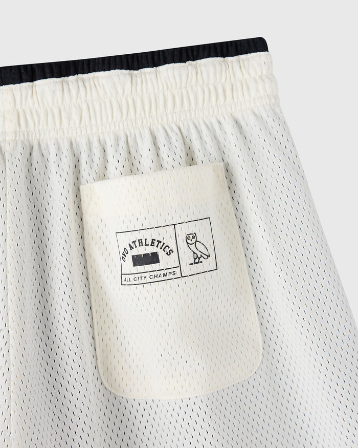Cream mesh shorts with black elastic waistband and front pocket featuring "Pro Athletics All City Champs" label.