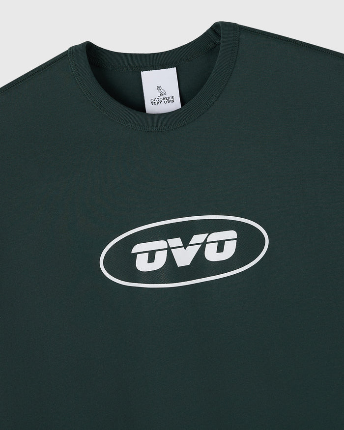Midnight green muscle tee with white oval "OVO" logo print on chest and brand label at neckline.