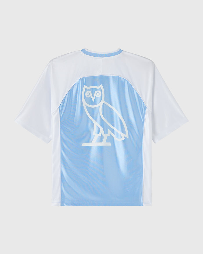 Light blue and white short-sleeve tee with owl graphic on chest and blue neckline trim.