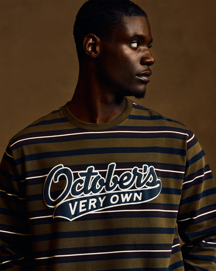 Moss green long-sleeve tee with navy and white horizontal stripes and "October's Very Own" script graphic on chest.