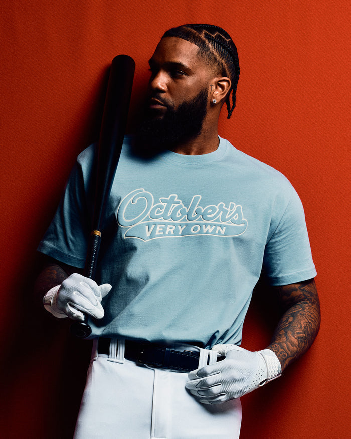Light blue t-shirt with "October's Very Own" script logo across chest.