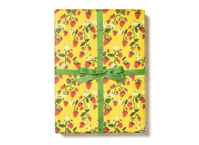 Floral strawberry gift wrap with green ribbon bow, yellow background