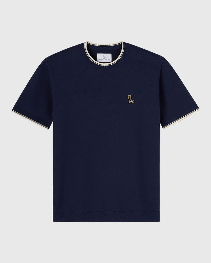 Navy short-sleeve sweater t-shirt with cream tipping on collar and cuffs, small owl emblem on chest.